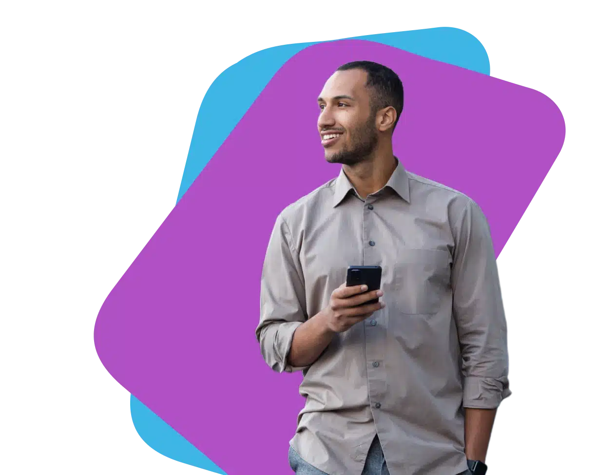 Man with a hand in his pocket and holding a phone in the other hand